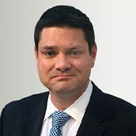 A headshot of Peter Corcoran Esq., a man in a suit and patterned tie, with 5 Star Reviews.